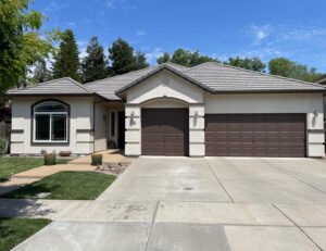 House painted white with garage doors in brown