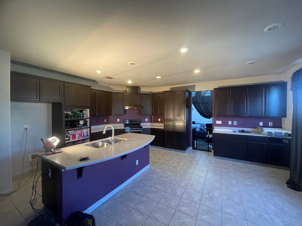 Kitchen with white cabinets, a central island, and light-colored walls